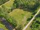 Aerial view showcasing a spacious grassy lot with road access surrounded by trees at 2331 Hollonville Rd, Brooks, GA 30205