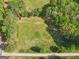 An aerial shot reveals a lush green field bordered by trees and a road, conveying a sense of peaceful, rural living at 2331 Hollonville Rd, Brooks, GA 30205