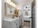 Bright bathroom with a white vanity, ornate mirror, and view of a bedroom with a white bed at 216 Southwick Ln, Peachtree City, GA 30269