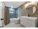 Gray and white bathroom featuring blue tiled shower, a dark framed mirror, and tile flooring at 216 Southwick Ln, Peachtree City, GA 30269