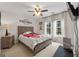 Cozy bedroom with a ceiling fan, a bed with a colorful blanket, and two large windows with white curtains at 216 Southwick Ln, Peachtree City, GA 30269