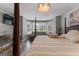 Bedroom featuring a decorative light fixture, wood floors, and a large window at 216 Southwick Ln, Peachtree City, GA 30269