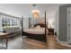 Bedroom featuring a decorative light fixture, wood floors, and a large window at 216 Southwick Ln, Peachtree City, GA 30269