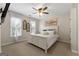 Comfortable bedroom with a white bed, ceiling fan, and two windows adorned with sheer curtains at 216 Southwick Ln, Peachtree City, GA 30269
