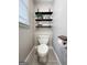 Cozy powder room featuring a toilet and decorative shelving at 216 Southwick Ln, Peachtree City, GA 30269