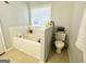 The bathroom features a tub, toilet, and beige tile floors at 7665 Antebellum Ln, Riverdale, GA 30274
