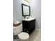 Bathroom with a dark vanity, bright mirror, and neutral decor at 7665 Antebellum Ln, Riverdale, GA 30274