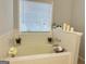 A well-lit bathroom boasts a large garden tub and decorative accents at 7665 Antebellum Ln, Riverdale, GA 30274