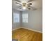 This room features hardwood floors, two large windows, and a ceiling fan at 7665 Antebellum Ln, Riverdale, GA 30274