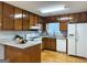 Functional kitchen space with hardwood floors, white appliances and granite countertops at 7665 Antebellum Ln, Riverdale, GA 30274