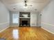 Bright and airy living room featuring a fireplace, hardwood floors, and natural light at 7665 Antebellum Ln, Riverdale, GA 30274