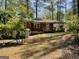 View of the backyard featuring a brick house with a wooden deck and partially fenced yard at 1815 Dodson Sw Dr, Atlanta, GA 30311