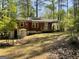 View of the backyard featuring a brick house with a wooden deck and partially fenced yard at 1815 Dodson Sw Dr, Atlanta, GA 30311