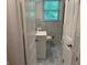 Hall bathroom featuring patterned tile, a sink and a toilet with a window at 1815 Dodson Sw Dr, Atlanta, GA 30311