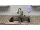 Well-maintained kitchen featuring a sink with a detachable faucet, stainless steel drain rack and granite countertops at 1815 Dodson Sw Dr, Atlanta, GA 30311