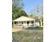 Angle shot of a one-story home featuring a welcoming covered porch and mature trees at 11755 Highway 36, Covington, GA 30014