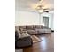 Inviting living room featuring hardwood floors, a ceiling fan, and a large sectional sofa at 11755 Highway 36, Covington, GA 30014
