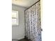 An elegant shower with white subway tile, window, and stylish shower curtain at 11755 Highway 36, Covington, GA 30014