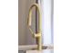Close up of a gold kitchen sink faucet with pull down nozzle and marble counter top at 185 Wadley Nw St, Atlanta, GA 30314