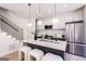 Open concept kitchen with island, stool seating, stainless steel appliances, and stairway access at 185 Wadley Nw St, Atlanta, GA 30314
