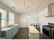 Bright kitchen featuring stainless steel appliances, an island, and vintage-style pressed tin ceiling at 30 Poplar St, Porterdale, GA 30014