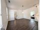 Bright living room with hardwood floors, white walls, and modern light fixtures; a gateway to the kitchen and a bedroom at 30 Poplar St, Porterdale, GA 30014