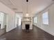 A rustic fireplace sits at the center of the living room, flanked by windows and doorways, with dark floors at 30 Poplar St, Porterdale, GA 30014