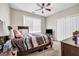 Simple bedroom with carpet, a ceiling fan, a dark wood bedframe, and a large window for light at 803 Baugh Springs Ln, Lawrenceville, GA 30044