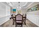 Dining room featuring a tray ceiling, elegant table, and wainscoting details at 803 Baugh Springs Ln, Lawrenceville, GA 30044