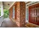 Charming front porch with brick facade, wood-look flooring, and a welcoming front door at 803 Baugh Springs Ln, Lawrenceville, GA 30044