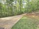 Long concrete driveway cutting through lush trees and manicured lawn, leading to a private residence at 64 Shadow Ct, Palmetto, GA 30268