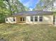 Back exterior view of a single-story home featuring a neutral siding, multiple windows, and a covered patio at 64 Shadow Ct, Palmetto, GA 30268