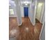 Hallway featuring hardwood flooring, neutral paint, and natural light streaming through the nearby dining room at 64 Shadow Ct, Palmetto, GA 30268