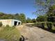 A view of the storage shed with ample surrounding land on a bright day at 2450 Highway 155 N, Mcdonough, GA 30252