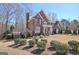 Stunning brick home with a lush landscaped yard, mature trees, and a pergola at 319 Corrigan Trce, Peachtree City, GA 30269