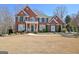 Stately brick home featuring manicured landscaping, green shutters, and a welcoming front porch at 319 Corrigan Trce, Peachtree City, GA 30269
