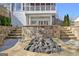 A backyard fire pit with surrounding stone patio and the exterior of the home behind it at 319 Corrigan Trce, Peachtree City, GA 30269