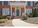 Inviting front porch with rocking chairs, decorative plants, and a beautiful green door at 319 Corrigan Trce, Peachtree City, GA 30269