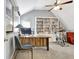 Well-lit home office with vaulted ceiling, bookshelf, desk, and exercise equipment at 319 Corrigan Trce, Peachtree City, GA 30269