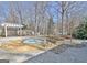 Backyard with a stone patio with a hot tub surrounded by trees and a pergola at 319 Corrigan Trce, Peachtree City, GA 30269