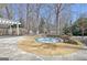 Stone patio featuring a hot tub, pergola, and outdoor seating surrounded by mature trees at 319 Corrigan Trce, Peachtree City, GA 30269