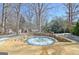 Outdoor hot tub with blue tile trim, set in a stone patio with surrounding landscaping at 319 Corrigan Trce, Peachtree City, GA 30269