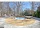 Hot tub with stone surround on the patio with mature trees and landscaping around the yard at 319 Corrigan Trce, Peachtree City, GA 30269