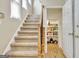 Carpeted stairway with wood banister leading to a pantry at 319 Corrigan Trce, Peachtree City, GA 30269
