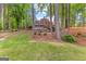 Serene backyard features mature trees and a custom fire pit area with a partial view of the home at 226 Le Paradis Blvd, Sharpsburg, GA 30277