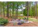 Beautiful backyard featuring a custom fire pit with seating overlooking scenic lake and lush landscaping at 226 Le Paradis Blvd, Sharpsburg, GA 30277