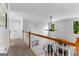 Hallway overlooking a living room fireplace with white painted walls, wood trim, and carpet flooring at 226 Le Paradis Blvd, Sharpsburg, GA 30277