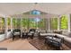 Relaxing sunroom with wicker furniture and views of the wooded backyard and lake at 226 Le Paradis Blvd, Sharpsburg, GA 30277