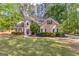 Charming home with a manicured lawn, complemented by flowering bushes, lush greenery, and a red front door at 226 Le Paradis Blvd, Sharpsburg, GA 30277