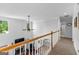 Bright hallway featuring neutral tones, a wooden railing, and views of the living area below at 226 Le Paradis Blvd, Sharpsburg, GA 30277